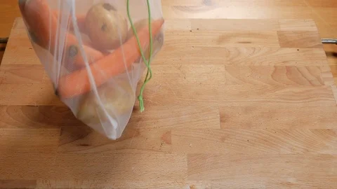 Zero waste lifestyle concept. Pull off carrots and potatoes of the reusable b Video stock 107262604