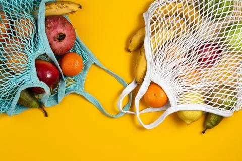 Zero waste plastic free concept. Fresh fruit in a mesh net bag, top view with Stock Photos
