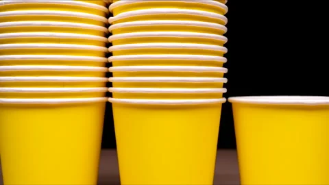 ZERO WASTE: Yellow paper cups line up vertically Stock Footage 181792953