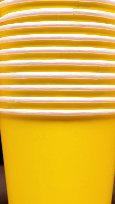 ZERO WASTE: Yellow paper cups line up vertically Stock Footage 344860422