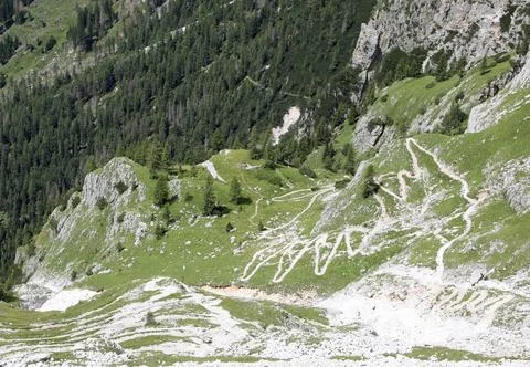 Zig zag footpath descending the steep slope of the Dolomite alps in Italy i.. Photos
