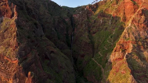 Zig zag mountain pass and waterfall down cliff at seaside Paul do Mar, aerial Stock Footage 321037724
