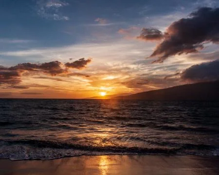 Zigzag incoming wave train at sunset on Maui beach, Lanai in the distance Stock Photos