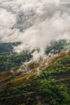 Zigzag path up the mountain through the fog Stock Photos