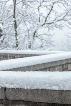 Zigzag wall covered in snow and tree in the blurred background Stock Photos