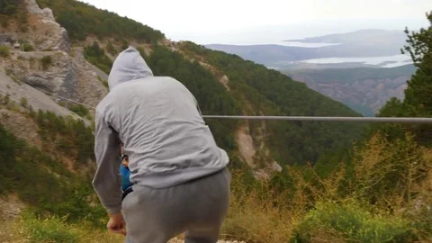 Zip-line in mountains. Man helps a woman to lounch pushing her for higher speed Video stock 83123413