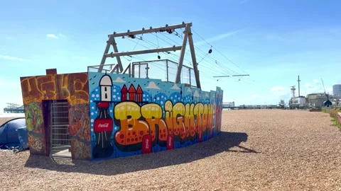 Zip Wire with colorful graffiti on Brighton beach next to tent Stock Footage 336394820