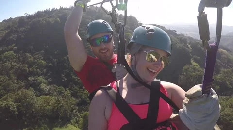 Ziplining couple having fun flying Stock Footage 63503758