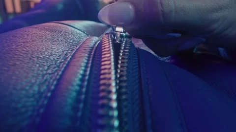Zipper on a Leather Jacket Being Closed by a Person in Blue Light 库存影片 331098888