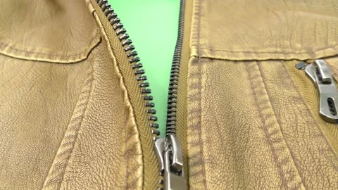 The zipper opens on the brown leather jacket. Green background. Chromakey. Stock Footage 140170462