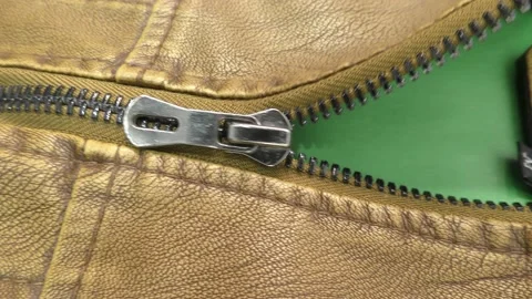 The zipper opens on the brown leather jacket. Green background. Chromakey. Stock Footage 140170606