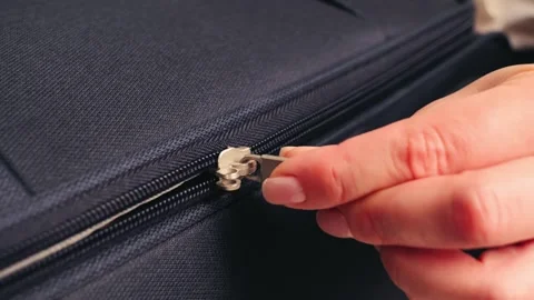 Zipper on suitcase close up, fingers pull at the zipper tab. Packing bags Stock Footage 325186529