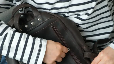 Zipping up plastic zipper on leather backpack slow motion Stock Footage 293296684