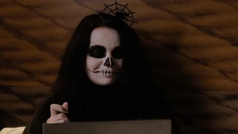 Zombie girl eats brain jam, looks at a laptop and laughs. Halloween eve.Close-up Stock-Footage 141899411