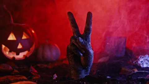 Zombie hand raising two fingers up showing peace from grave.Halloween, V victory Stock Footage 253998079
