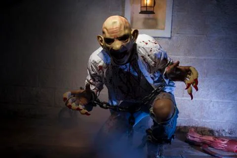Zombie, Man chained with blood and knife, has a severed leg blood Stock Photos