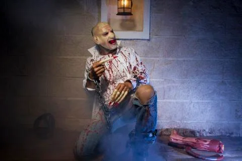 Zombie, Man chained with blood and knife, has a severed leg blood Stock Photos