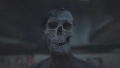 Zombie skull and corpse in the evening twilight with concrete walls in the Stock Footage 225333063