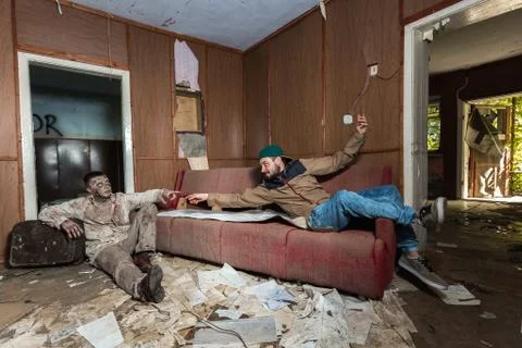 Zombies and people are stretching their hands to each other in an abandoned h Stock Photos