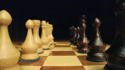 Zoom in between two rows of white and black chess pieces on wooden chessboard Stock Footage 149324757