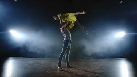 Zoom camera, two modern ballet dancers are dancing on stage in smoke a man Stock Footage 114693711