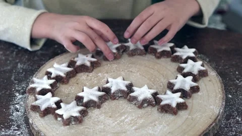 Zoom on child hands putting ginger homemade biscuits on a wooden plate, natural Stock Footage 256792835