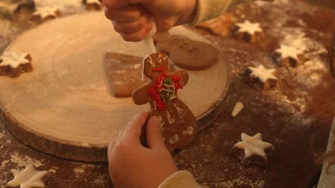 Zoom on child hands putting ginger man homemade biscuit on a wooden decorated Stock Footage 256969372