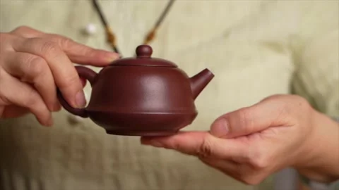Zoom in on a Chinese tea master shaking a kettle of tea Stock Footage 217369932