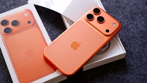 Zoom Close Up of Orange iPhone 17 Pro on Box with Packaging and Accessories on Stock Footage 317695942