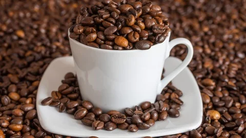 Zoom in on coffee cup with coffee beans Stock Footage 105281717