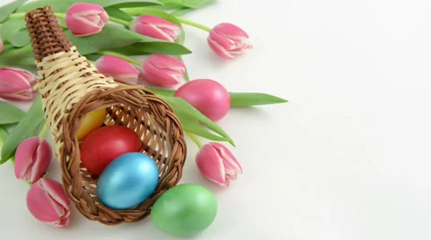 Zoom of cornucopia basket with bunch of pink tulips and Easter eggs Video stock 34132091