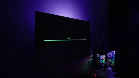 Zoom. Dark Room with Computer Setup, Monitor Showing Green Loading Bar and Red Stock Footage 281461509