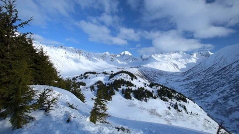 Zoom in of dramatic mountain range pass in mid winter Stock Footage 120896213