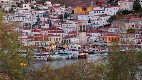 Zoom Drone View of Hydra Town Harbor and Church Through Tree Branches at Dusk Stock Footage 344067795