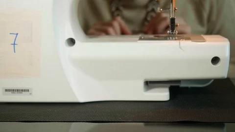 Zoom on focused white woman's hands on background. White electric sewing machine Stock Footage 118956897