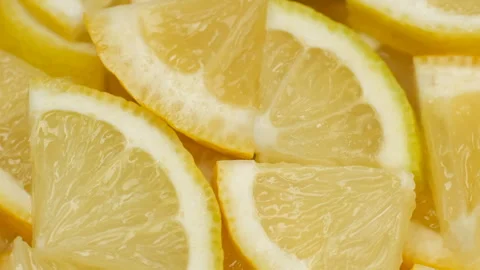 Zoom frame chopped fresh yellow lemon slices, rotation Stock Footage 305023827