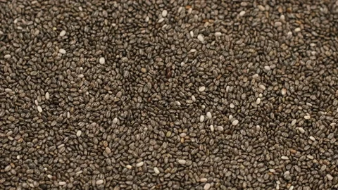 Zoom frame heap of dry chia seeds close up, rotate Stock Footage 329923628