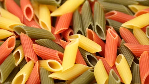 Zoom frame raw three coloured Italian pasta penne close up, rotation Video stock 250309400