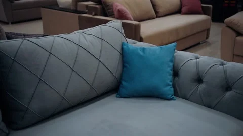 Zoom frame to a small blue pillow on a cozy gray couch. 4k video. Stock Footage 235058249