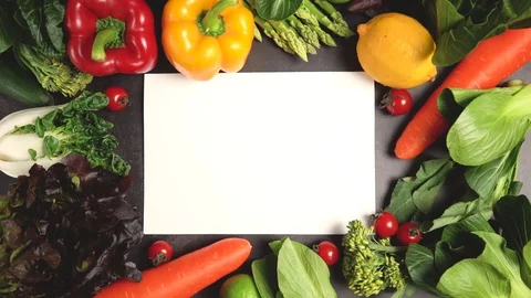 Zoom in fresh organic vegetables setting on table and blank white pa Stock Footage 128389761
