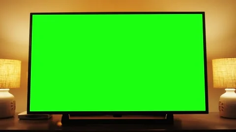 Zoom in of a horizontal green screen TV. Cozy evening living room. Stock Footage 259334505