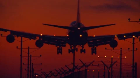 Zoom in on large plane landing at sunset Video stock 8839484