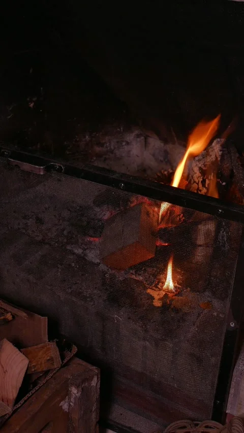 Zoom in: logs burning intensely inside a fireplace. Pieces of wood burn Stock Footage 342705817