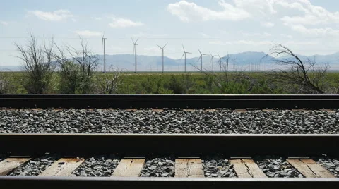 Zoom in-Low angle-Railroad tracks to wind turbines Stock Footage 64681019