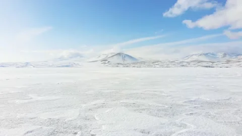 Zoom in low angle view of icy lake surface texture with mountains background. Vidéo 149729630