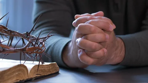 Zoom In of Man Praying With Hands beside Bible and Crown of Thorns. 스톡 동영상 129684437