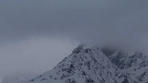 Zoom mists passing in speed over the snowcovered tops of some mountains Stock Footage 71756777