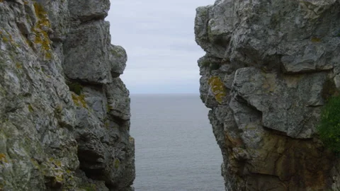 Zoom on the ocean between two rocks on a cliff, in Brittany, France Stock Footage 229757792