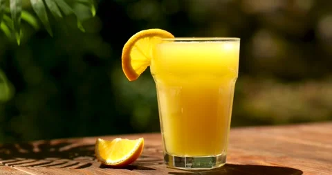 Zoom orange juice on the table outside. Summer holidays Stock Footage 246877257
