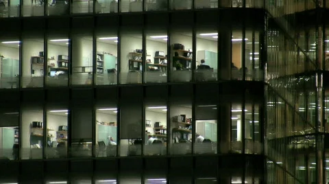 Zoom out and in to brightly lit City Hall office block at night London England Stock Footage